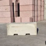 Betonblocks in Sandstein und Rot im Werkslager, vorn ein Standardblock