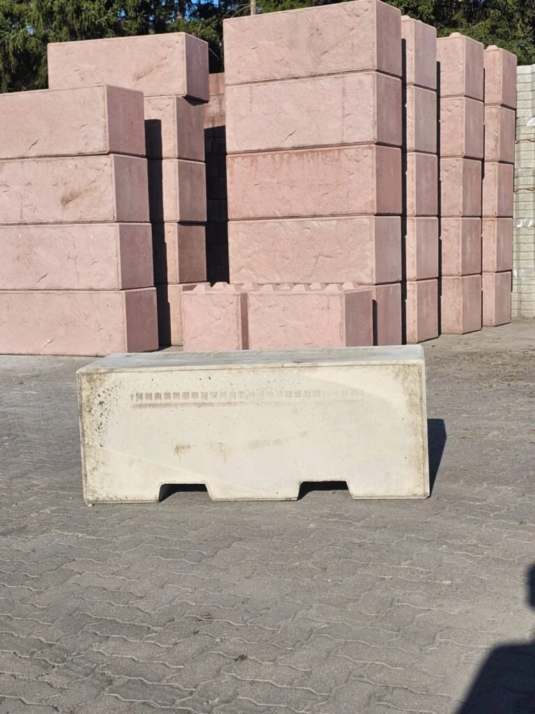 Betonblocks in Sandstein und Rot im Werkslager, vorn ein Standardblock