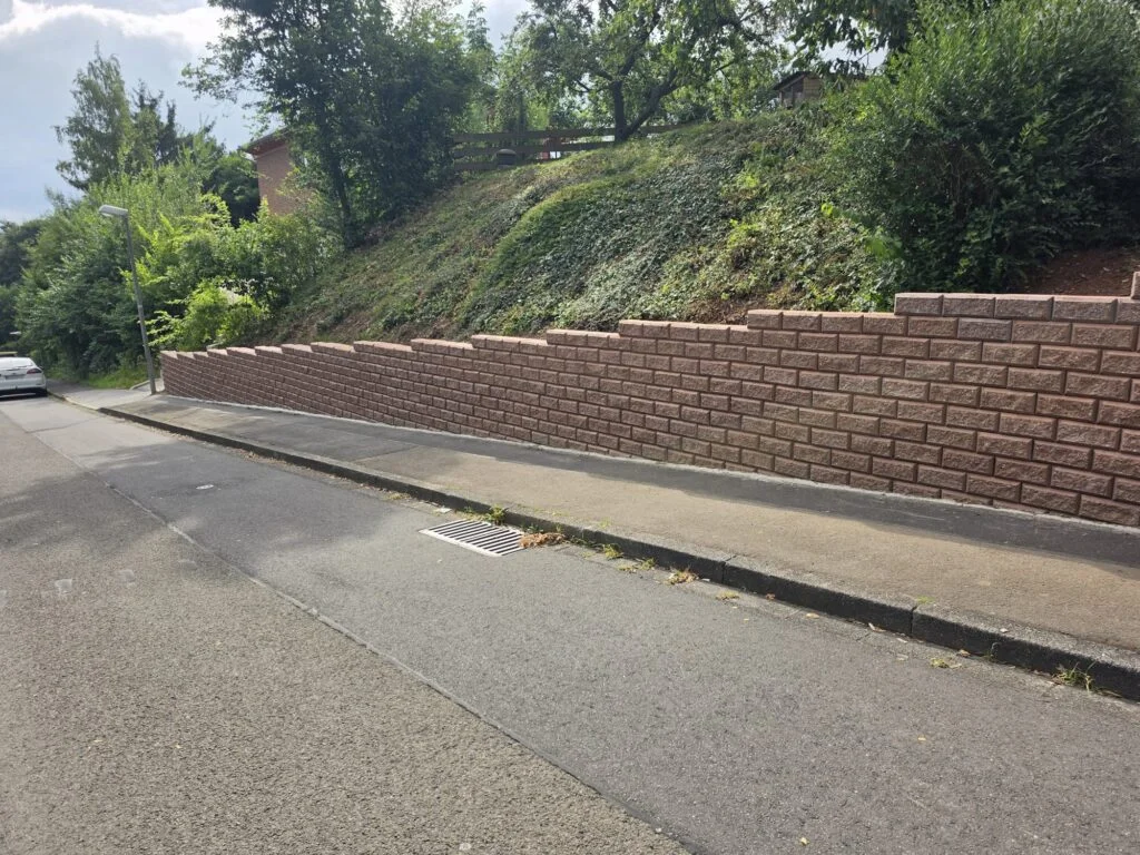 Gardoboss-Mauer in Herbstlaub entlang der Straße