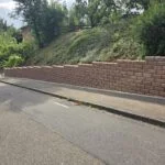 Gardoboss-Mauer in Herbstlaub entlang der Straße