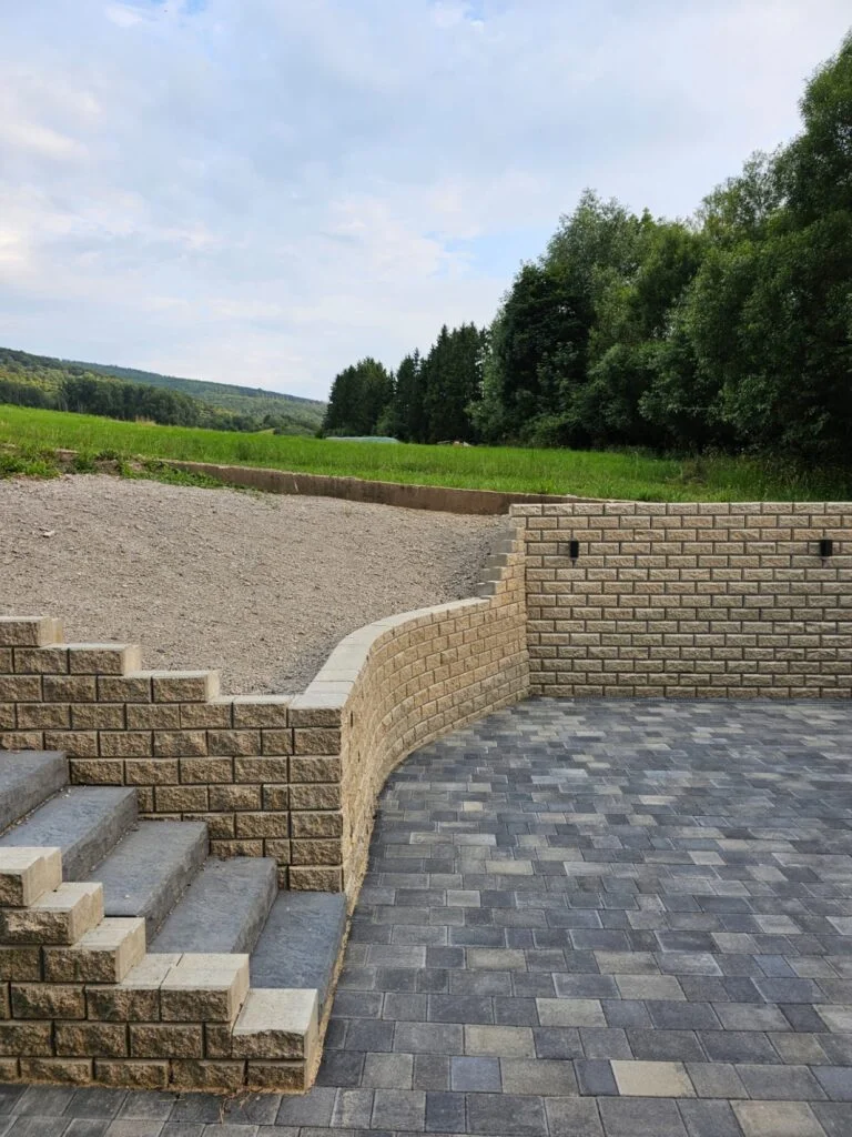Treppe aus Blockstufen mit Mauer und gepflastertem Hof